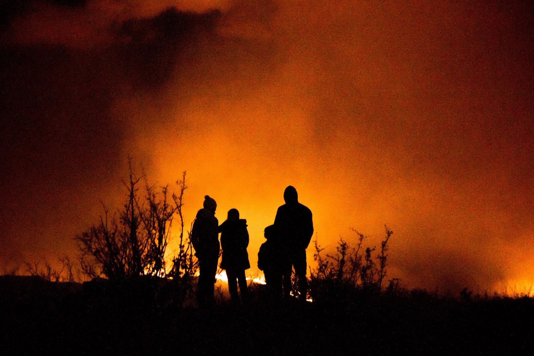 Silhouette of family watching wildfire.