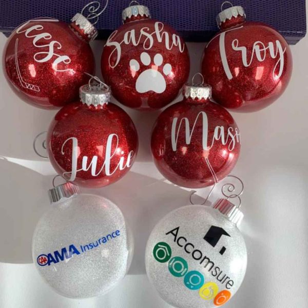Seven custom-made tree ornaments with the labels: “Jesse”, “Sasha”, “Troy”, “Julie”, “Mason”, “AMA Insurance”, and “Accomsure”.