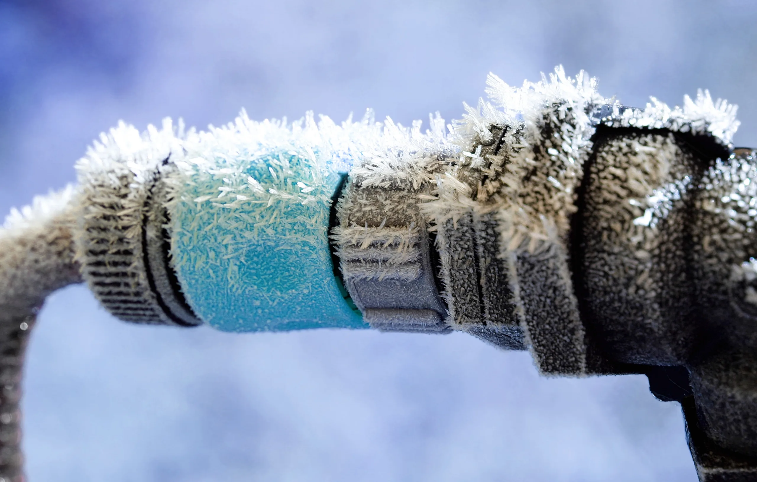 An outdoor hose covered in frost.