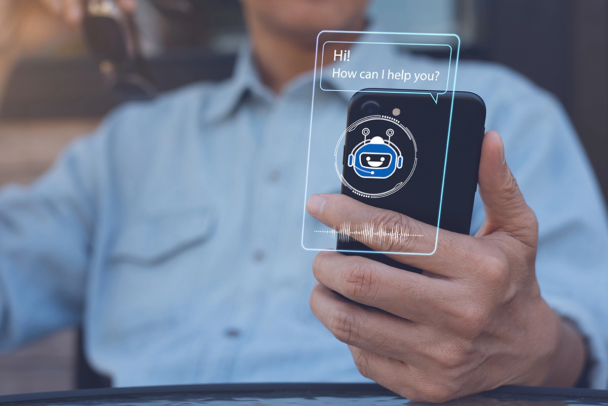 A person on their mobile device with a chatbot saying “Hi! How can I help you?”
